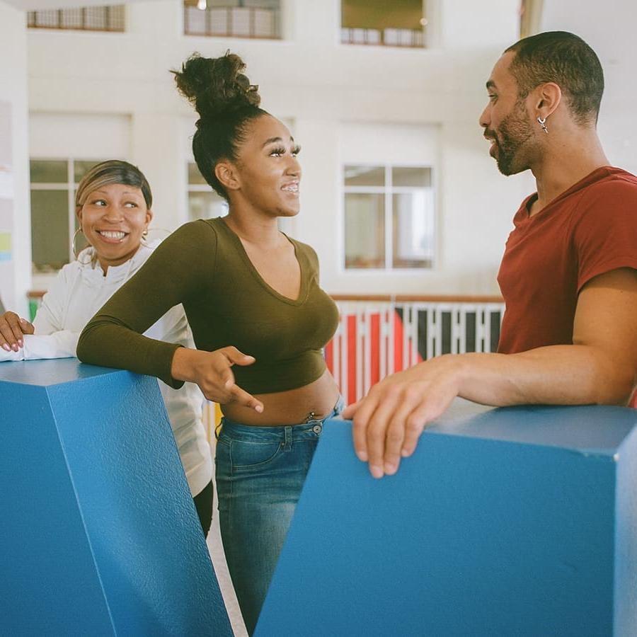 3 students pose by UMB in Campus Center